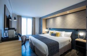 a hotel room with a large bed and a television at Best Western Plus Opéra Batignolles in Paris