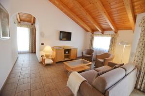 a living room with a couch and a tv at Residence Alle Palme in Riva del Garda