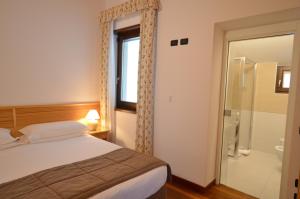 een slaapkamer met een bed en een glazen douche bij Residence Alle Palme in Riva del Garda