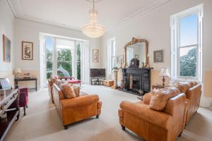 a living room filled with furniture and a mirror at Stunning Apartment in Victorian Villa with Garden in Torquay