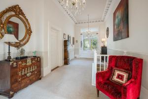 a living room with a red chair and a mirror at Stunning Apartment in Victorian Villa with Garden in Torquay