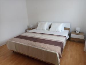 ein Schlafzimmer mit einem großen Bett mit zwei Nachttischen in der Unterkunft Apartment Bella in Pula
