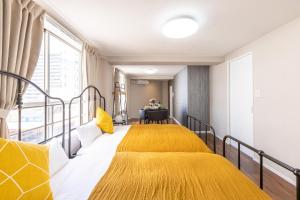ein Schlafzimmer mit einem gelben Bett und einem Tisch in der Unterkunft アリタ日本橋西3F in Osaka
