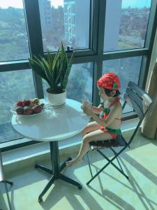 岑山的住宿－Tuấn Đạt Luxury FLC Sầm Sơn，坐在桌子旁的椅子上的娃娃