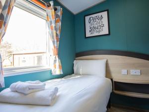 a bedroom with a bed with towels on it at Cleethorpes Pearl Holiday Park in Humberston +10 photos