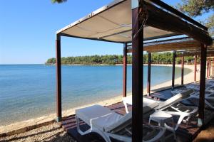 a group of lounge chairs on the beach at ANA A2, 60 m2 in Novigrad Istria +23 photos