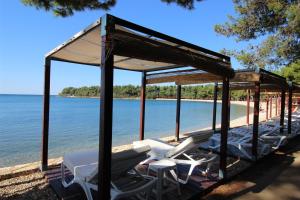 a group of chairs and tables on a beach at ANA A2, 60 m2 in Novigrad Istria