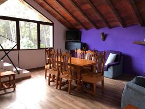 une salle à manger avec une table et un mur violet dans l'établissement Casas Rurales Hoya Calvete, à Yeste