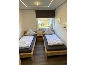 two beds in a room with a window at Möwenblick - a57230 in Cuxhaven