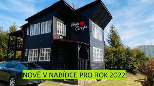 una casa nera con una macchina parcheggiata di fronte di Chata Terezka a Jedovnice