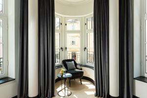 Habitación con ventanas con silla y mesa. en Hotel Schillerhof, Weimar, en Weimar