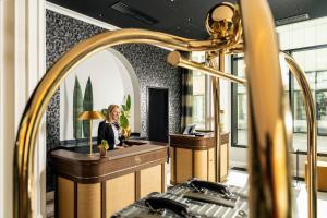 a woman sitting at a counter in a room at Hotel Schillerhof, Weimar in Weimar