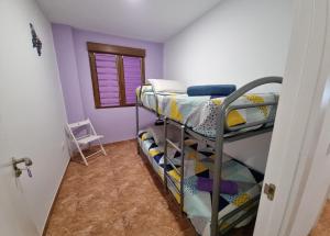 - une chambre avec des lits superposés dans une chambre aux murs violets dans l'établissement Apartamento Camino Al Castillo, à Xàtiva