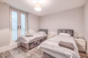 a bedroom with two beds and a window at APARTMENT 2 and 4 - PORTRUSH MARINE APARTMENTS in Portrush +19 photos