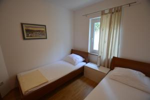 a small bedroom with two beds and a window at Apartment Silva in Kornić