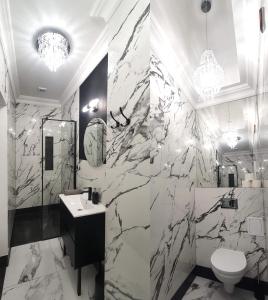 ein Badezimmer mit einer schwarz-weißen Marmorwand in der Unterkunft DK Premium Ballady i Romanse in Olsztyn + 36 Fotos