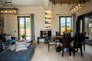 sala de estar con mesa y sofá azul en Luxury Villa Chrisi en Svoronata