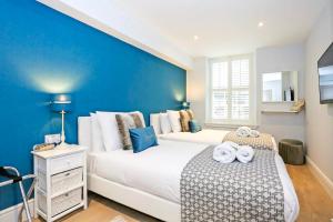 a bedroom with two beds and a blue wall at Modern 3 Bedroom Apartment, West End in Edinburgh