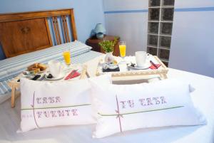 
a hotel room with a bed, coffee table, and pillows at Hotel Casa de la Fuente in Alcorisa
