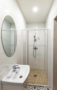 La salle de bains est pourvue d'un lavabo et d'une douche. dans l'établissement Apartamentai Laima, à Druskininkai