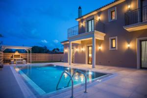 a villa with a swimming pool in front of a house at Luxury Villa Chrisi in Svoronata