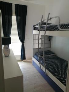 a bedroom with two bunk beds and a window at CASA Chloe' in Lido di Jesolo