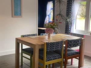 a dining room table with chairs and a wooden table at Bramble Cottage on the edge of Exmoor in Combe Martin
