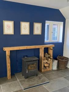 eine blaue Wand mit einem Holzofen in einem Zimmer in der Unterkunft Bramble Cottage on the edge of Exmoor in Combe Martin