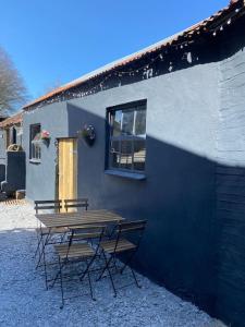 einem Picknicktisch und Stühlen außerhalb eines Gebäudes in der Unterkunft Bramble Cottage on the edge of Exmoor in Combe Martin