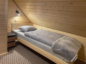una camera con un letto su una parete in legno di Domki Pod Beskidem a Wysowa-Zdrój