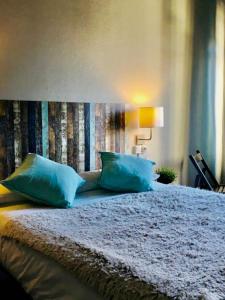 1 dormitorio con 1 cama con almohadas azules en Zentric Hostel, en León