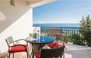 een tafel en stoelen op een balkon met uitzicht op de oceaan bij Vila Jadran in Omiš