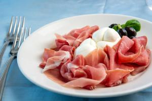 a plate of food with meat and vegetables on a table at Hotel Albatros in Ischia