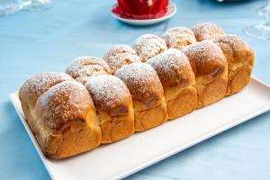 a plate of donuts covered in sugar on a table at Hotel Albatros in Ischia