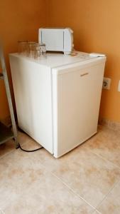 a white refrigerator sitting on top of a floor at Casa de Vasco in Amora