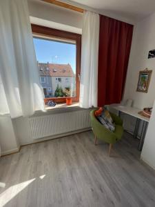 ヘンミンゲンにあるmaggies-home-hannoverのリビングルーム(緑の椅子、窓付)