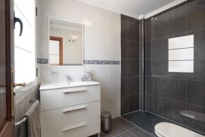 y baño con lavabo y ducha. en Comfortable and modern apartment next to the Avenida central in Tías, en Tías