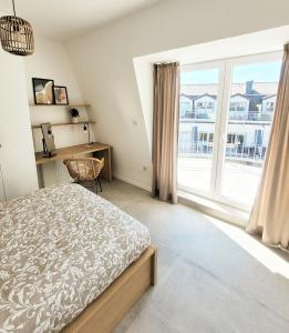 sypialnia z łóżkiem i dużym oknem w obiekcie Pine Point Apartament with terrace, shared pool, tennis court w Pobierowie