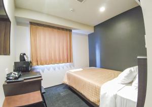 Postel nebo postele na pokoji v ubytování HOTEL LiVEMAX Kokura Ekimae