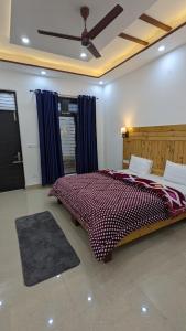 a bedroom with a large bed with blue curtains at HOTEL HIMALAYAN FOXHOLE in Chakrāta
