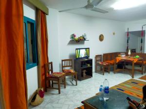 a living room with a tv and a table and chairs at 2 bedroom challet with private garden at Riviera beach resort Ras Sudr,Families only in Ras Sedr