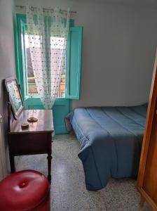 a bedroom with a bed and a table and a window at Casa Albano in Baldellou