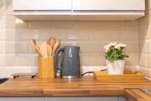 a kitchen counter with a coffee pot and utensils at Lovely 2BR AP just moments away from Brighton Beach in Brighton & Hove