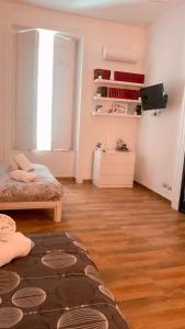 sala de estar con cama y suelo de madera en I Gironi di Dante, en Nápoles