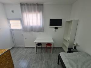 Habitación pequeña con mesa y 2 sillas en Budget Apartment LeLo Center1 en Osijek
