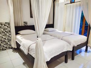 Postel nebo postele na pokoji v ubytování Batik Sekar Bali Guest House