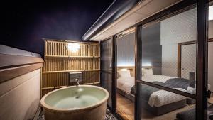 een badkamer met een bad en een slaapkamer bij AWA Nishi-Izu in Numazu