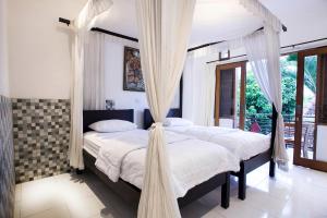 Postel nebo postele na pokoji v ubytování Batik Sekar Bali Guest House