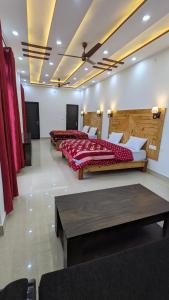 a bedroom with two beds and a table at HOTEL HIMALAYAN FOXHOLE in Chakrāta