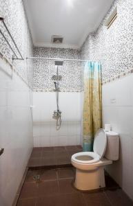 a bathroom with a toilet and a shower at Batik Sekar Bali Guest House in Ubud